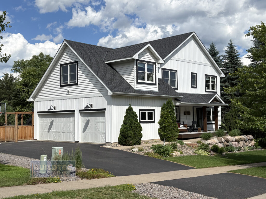 White two-story home with black trim and new charcoal roof and siding in the Legends of Stillwater neighborhood by Buildtec.