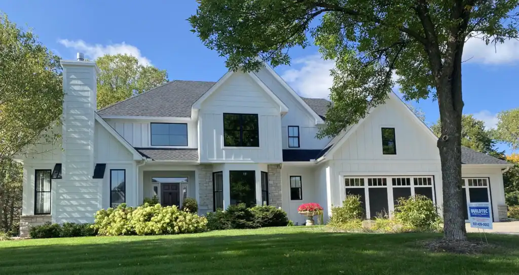 White modern farmhouse in Woodbury MN with new charcoal roof by Buildtec.