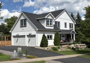 White two-story home with black trim and new charcoal roof and siding in the Legends of Stillwater neighborhood by Buildtec.